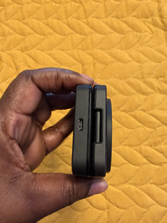 Store-supplied sample image of the side of a folded black charger against yellow fabric